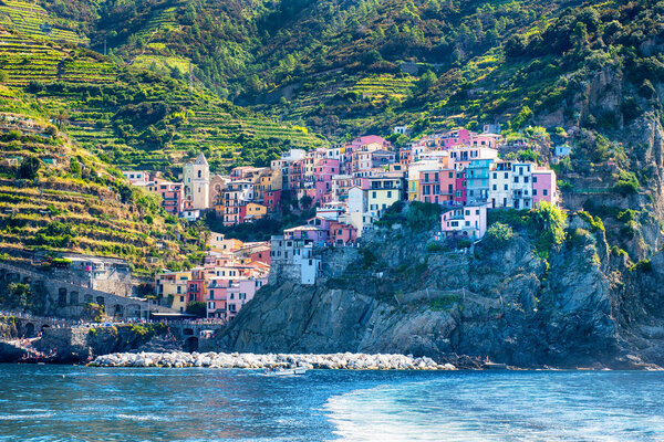 View of the colorful fishing village of Riomaggiore, Cinque Terre, Italy from the sea, a popular tourist destination and resort