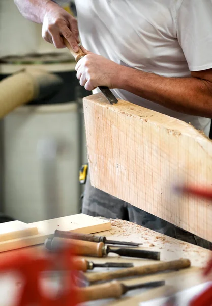 Tischler, der mit einem Meißel an einem Holzblock arbeitet — Stockfoto