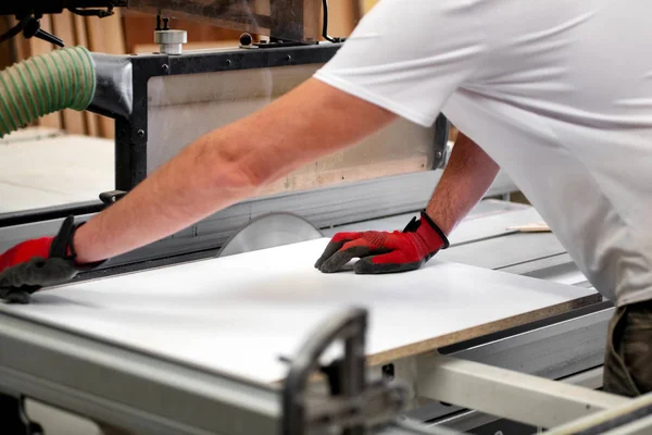 Carpenter cutting a white wooden panel — Stock Photo, Image