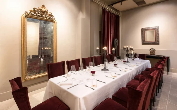 Lange tafel gedekt voor het diner in een luxe restaurant — Stockfoto