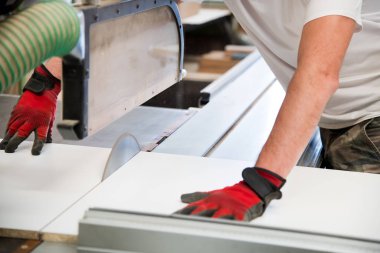 Dairesel testere kullanan bir marangozun elleri