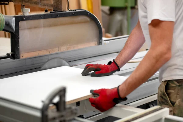 Carpenter sawing a wooden board on a circular saw — Stock Photo, Image