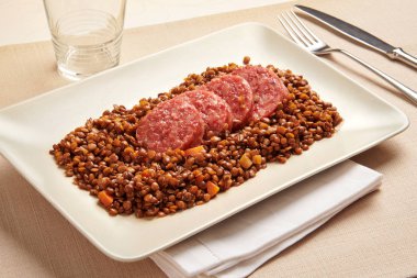 Cotechino ve mercimek tabakta servis edilir.