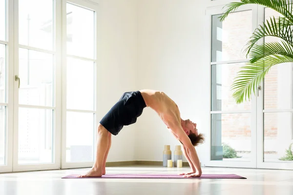 Shirtless Young Man Practicing Yoga Doing Bridge Pose Exercising Indoors — Stock Photo, Image