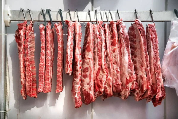 Fila Costillas Frescas Cerdo Crudas Colgadas Nevera Sobre Ganchos Metálicos — Foto de Stock