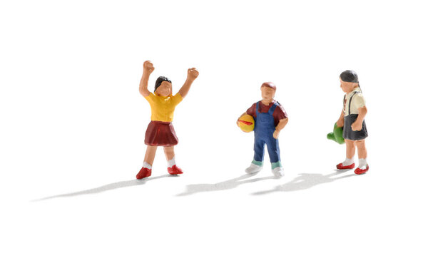 Three young miniature kids playing together with two little girls and a boy playing with a ball over a white background with shadow and copy space