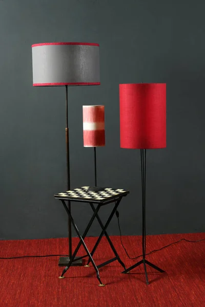 根据室内设计理念 用老式地板装饰红色和黑色室内装饰 并在灰色墙壁上打上圆柱形的台灯 — 图库照片