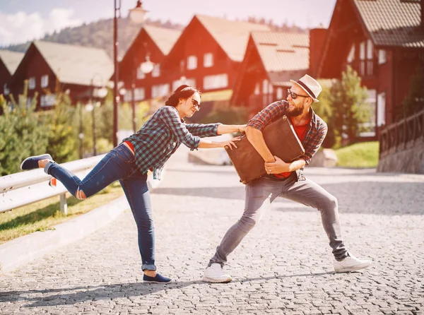 Miłości para walczy o walizki na ulicy. — Zdjęcie stockowe