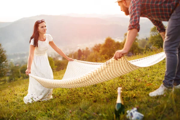 Coppia innamorata prepararsi per il picnic. plaid bianco sparso . — Foto Stock