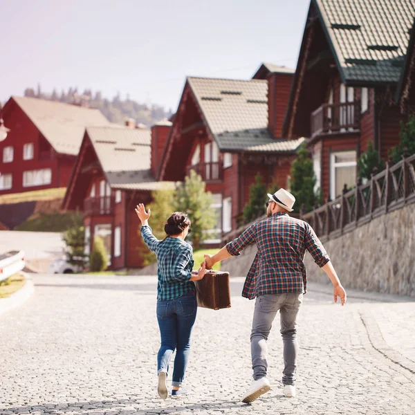 Coppia amorevole passeggiando per le vie della città con valigia — Foto Stock