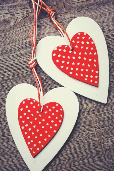 Cuori di Natale bianchi e rossi cuciti su sfondo di legno, per auguri San Valentino — Foto Stock
