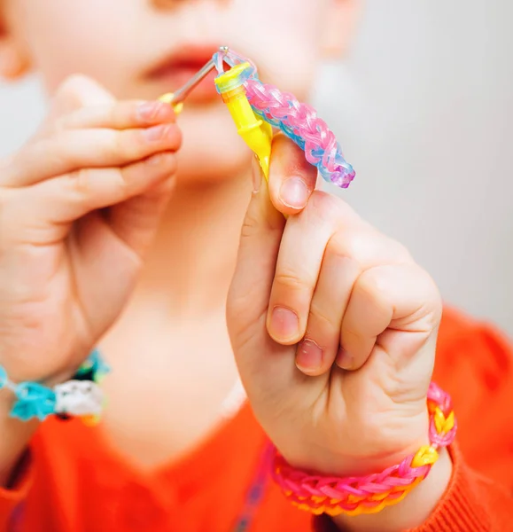 Menina tece pulseira, goma tecelagem — Fotografia de Stock
