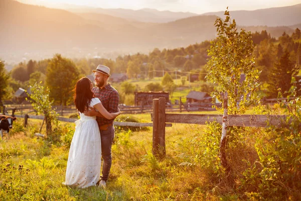 Loving para w górach w pobliżu ogrodzenia drewniane. — Zdjęcie stockowe