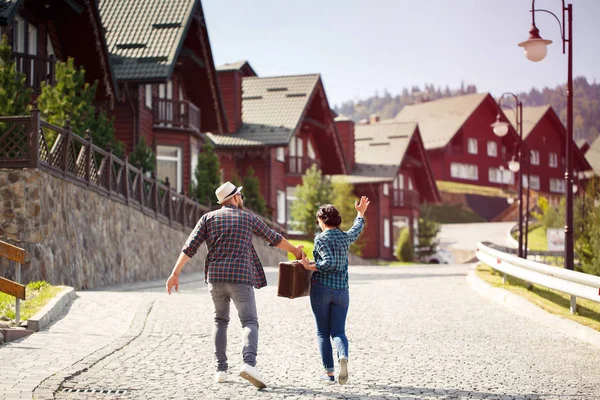 Coppia amorevole passeggiando per le vie della città con valigia — Foto Stock