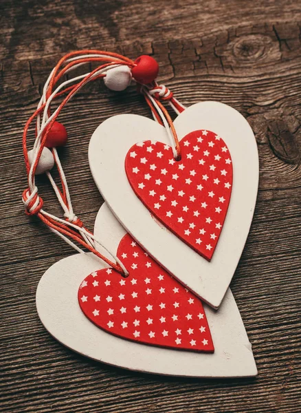 Vit och röd sydde jul hjärtan på trä bakgrund, för hälsningar alla hjärtans dag — Stockfoto