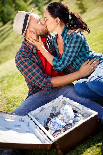 Älskande par i fältet på picknick. — Stockfoto