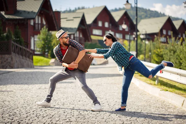 Coppia amorevole lotta per la valigia sulla strada della città . — Foto Stock