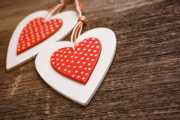 White and red sewed christmas hearts on wooden background — Stock Photo, Image