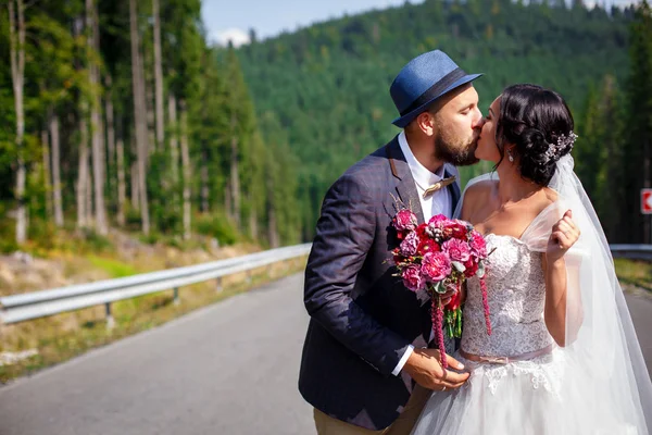 Po prostu żonaty para całuje na drodze — Zdjęcie stockowe