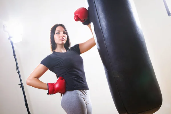 Sports girl in boxing gloves and body punching bag — Stock Photo, Image