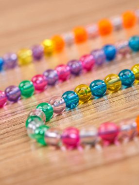 ahşap bir masa üzerinde renkli boncuklu yılan düzenlendiği