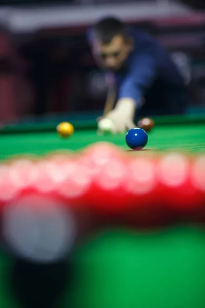 Jeune homme aligne son tir comme il casse les couilles pour le début du jeu de billard — Photo