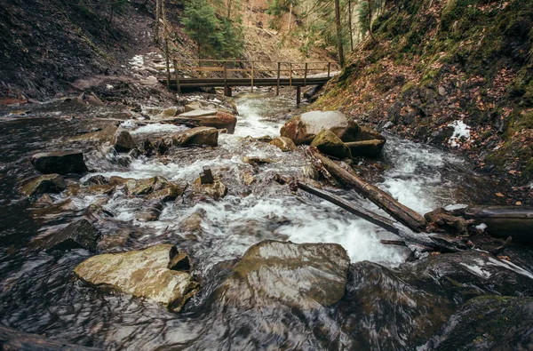 Rio de montanha e ponte de madeira — Fotografia de Stock