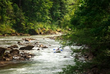 iki kişi bir Kano bir dağ nehir üzerinde yüzen