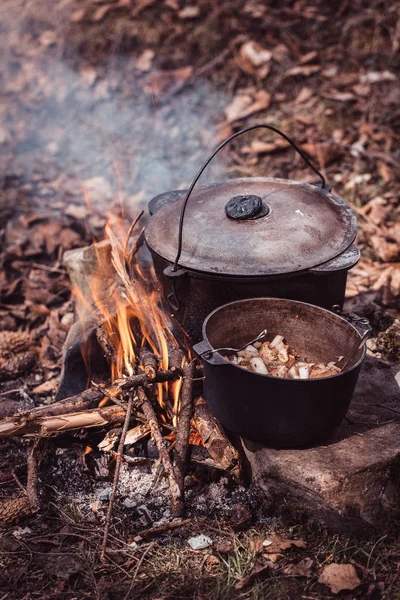 Cooking in the sooty cauldron on the open fire in woods.