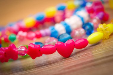 ahşap arka plan üzerinde renkli boncuklar yılan