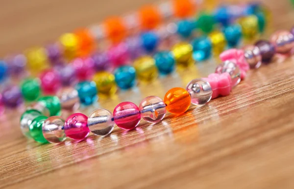 Decoration of glass beads lying on a wooden background.