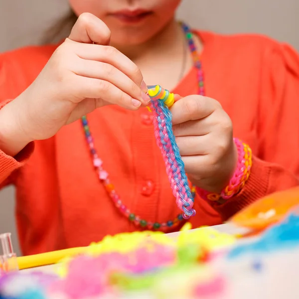 Portrait cute girl making rubber band bracelet — Stock Photo, Image