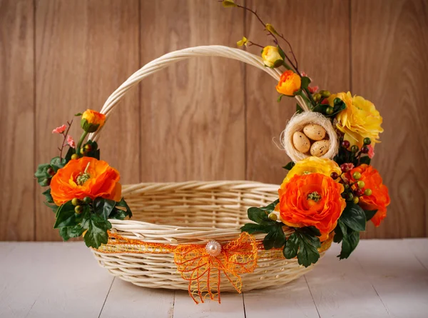 Ontwerper mand is versierd met bloemen. Rieten mand voor het vieren van Pasen en andere feestdagen. — Stockfoto