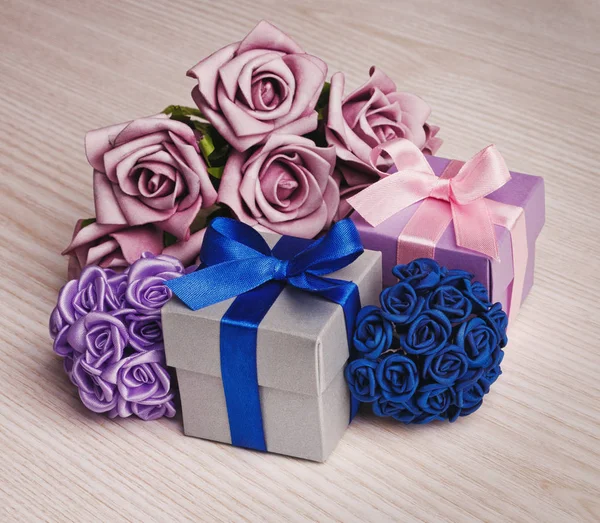 Подарочная коробка с букетом цветов на деревянном фоне — стоковое фото