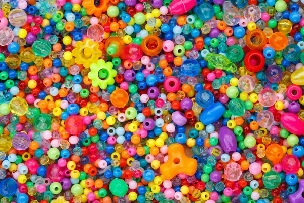 Montones de coloridas perlas de plástico fusibles utilizadas para las artes — Foto de Stock