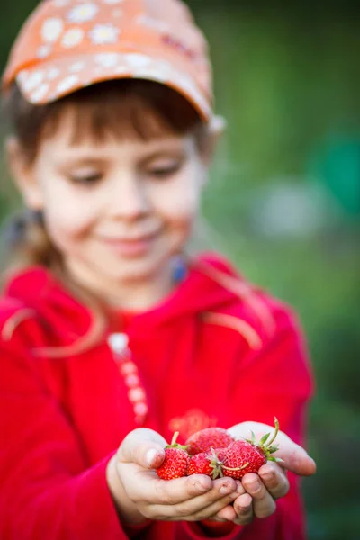 Beaucoup de fraises fraîches sur la main de la fille — Photo