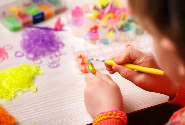 Bandas de goma de colores para tejer accesorios en las manos de una niña —  Fotos de Stock