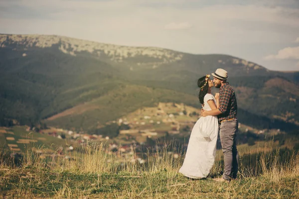 mutlu sevgi dolu çift ekose alanında oturup. arka plan mounta