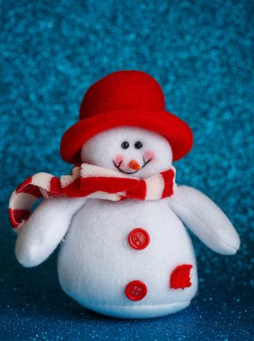 Kardan adam oyuncak eşarp ve soyut bokeh Arka kapakta giymiş gülümseyen.