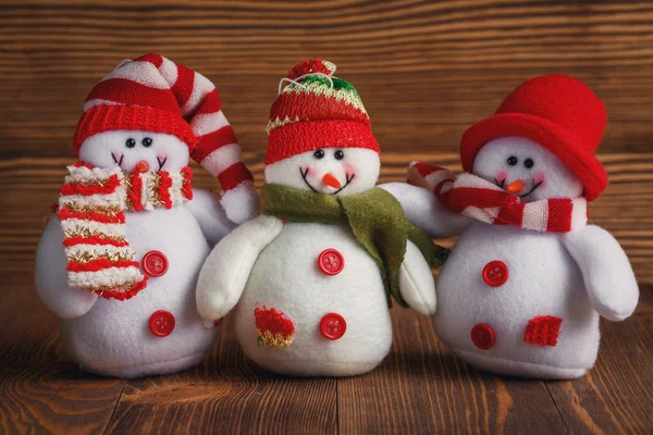 Gang o trzech snowmens Boże Narodzenie w czapki i szaliki. Nowe zabawki lat. — Zdjęcie stockowe