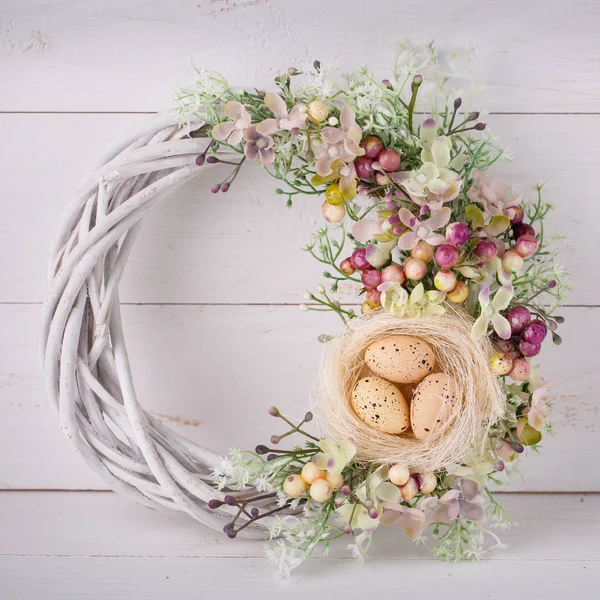 Decorative woven wreath is decorated with flowers and quail eggs. — Stock Photo, Image