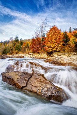 Huzursuz tehlikeli dağ nehir taşları ile. Aktif istirahat için dağlarda koyun. Sonbahar ormandaki nehir