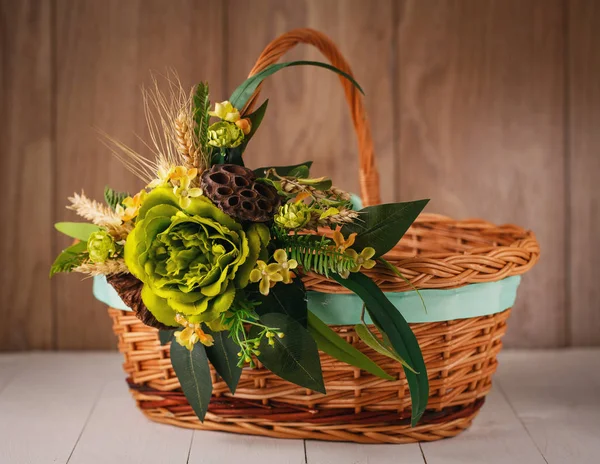Košík s květinami na oslavu Velikonoc na dřevěném pozadí — Stock fotografie