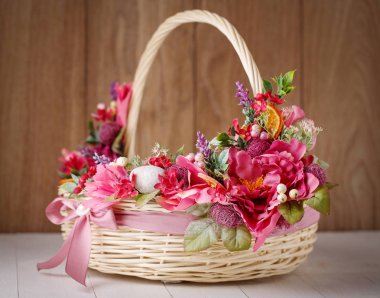 Ahşap bir arka planda Paskalyayı kutlamak için çiçekli sepet.