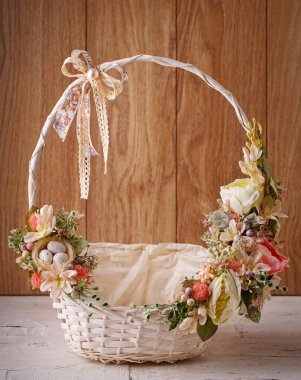 Ahşap bir arka planda Paskalyayı kutlamak için çiçekli sepet.