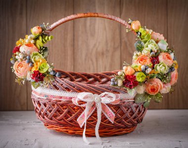 Ahşap bir arka planda Paskalyayı kutlamak için çiçekli sepet.