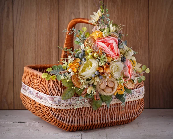 Festive basket decorated with flowers on wooden background. — Stock Photo, Image