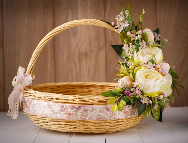 Feestelijke mand, versierd met bloemen op houten achtergrond. — Stockfoto