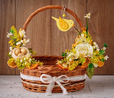 Ahşap bir arka planda Paskalyayı kutlamak için çiçekli sepet.