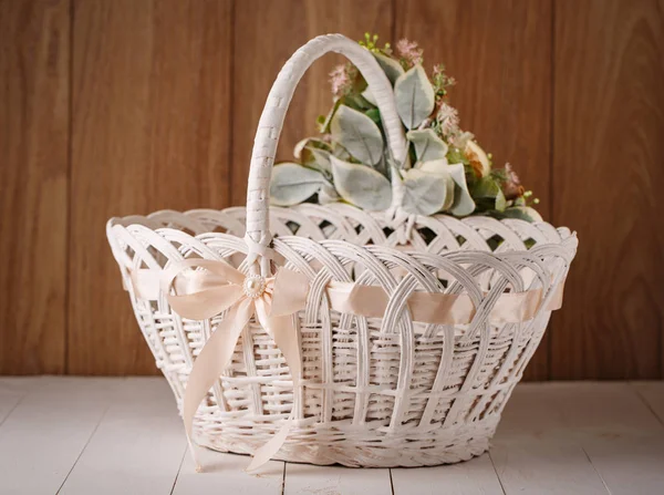 Basket with flowers to celebrate Easter on a wooden background — Stock Photo, Image